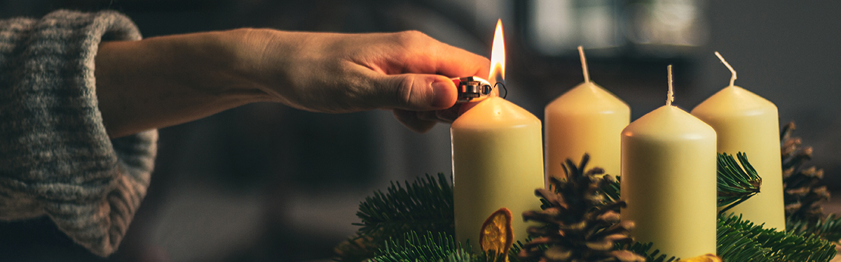 Lighting a candle on an advent wreath.